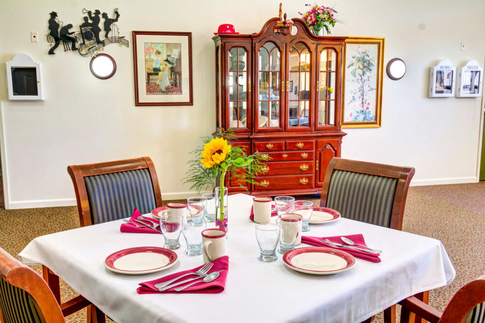 Table set with white tablecloth in the dining room at Callahan Court Memory Care in Roseburg, Oregon