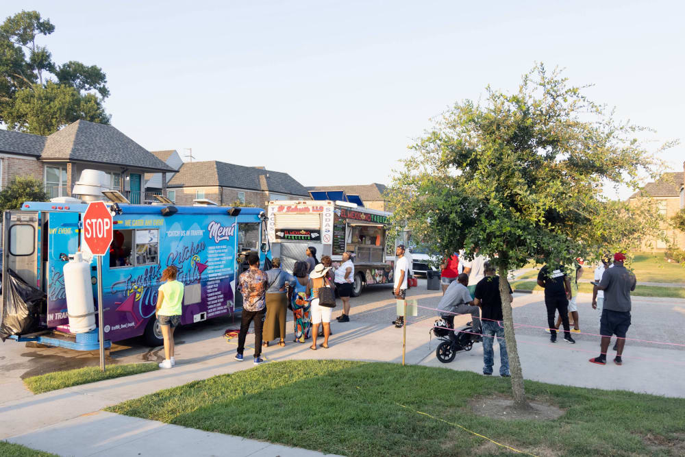 People gathering to buy on two food trucks at The Mayfair Apartment Homes in New Orleans, Louisiana