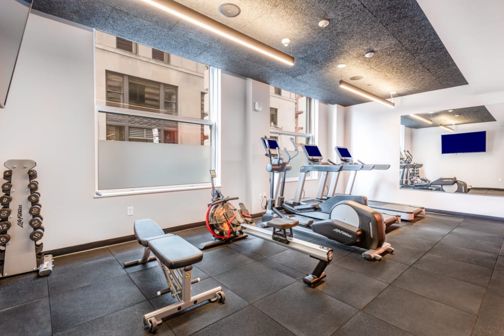 Community gym with weights and treadmills at One India Street Apartments in Boston, Massachusetts