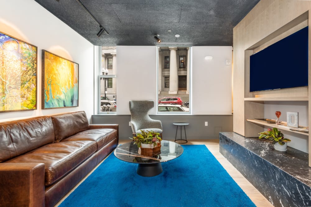 Trendy resident lounge with leather sofa and large television at One India Street Apartments in Boston, Massachusetts