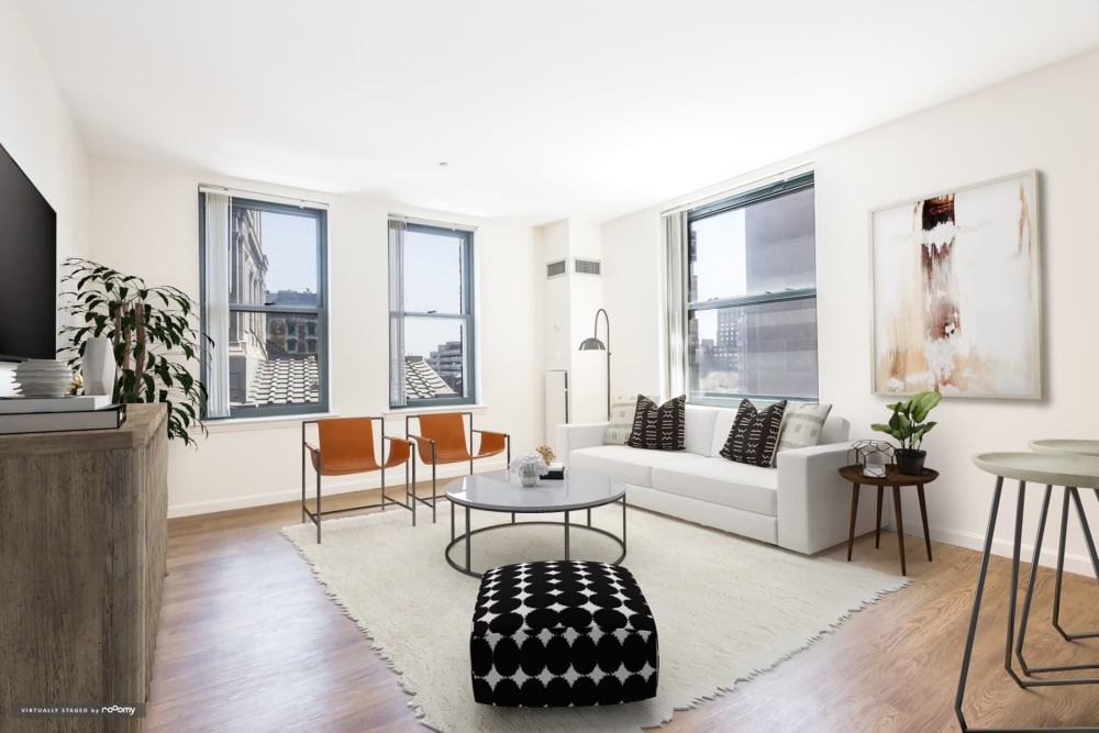 Large apartment living room with hardwood floors and city views at One India Street Apartments in Boston, Massachusetts