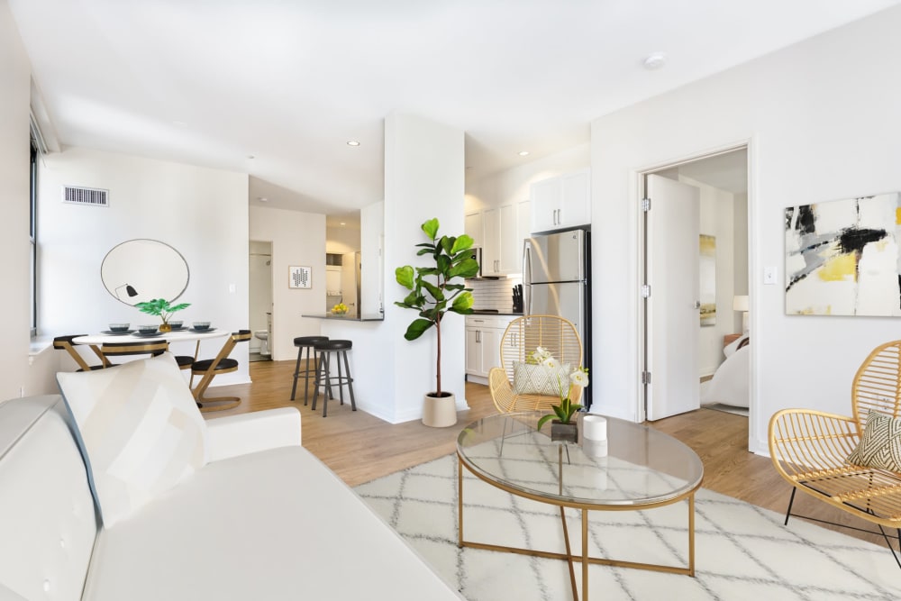 Apartment living room with large area rug, glass coffee table, and white sofa at One India Street Apartments in Boston, Massachusetts