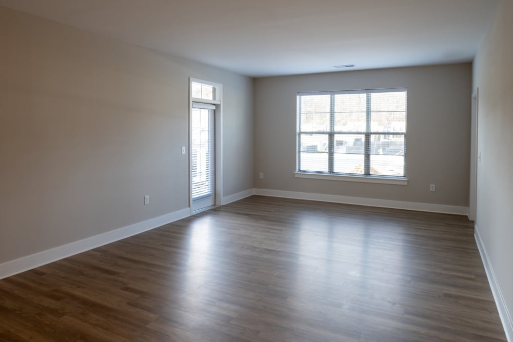 Spacious living room with hardwood-inspired flooring at Elms at the Refuge in Laurel, Maryland