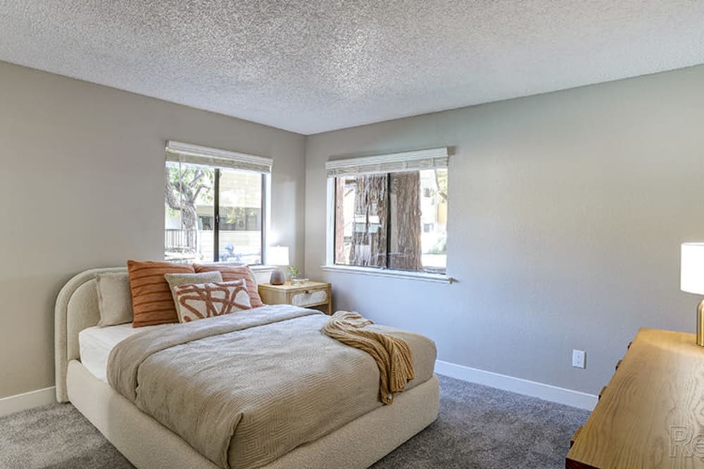 Model bedroom with soft carpet at Austin Commons Apartments in Hayward, California