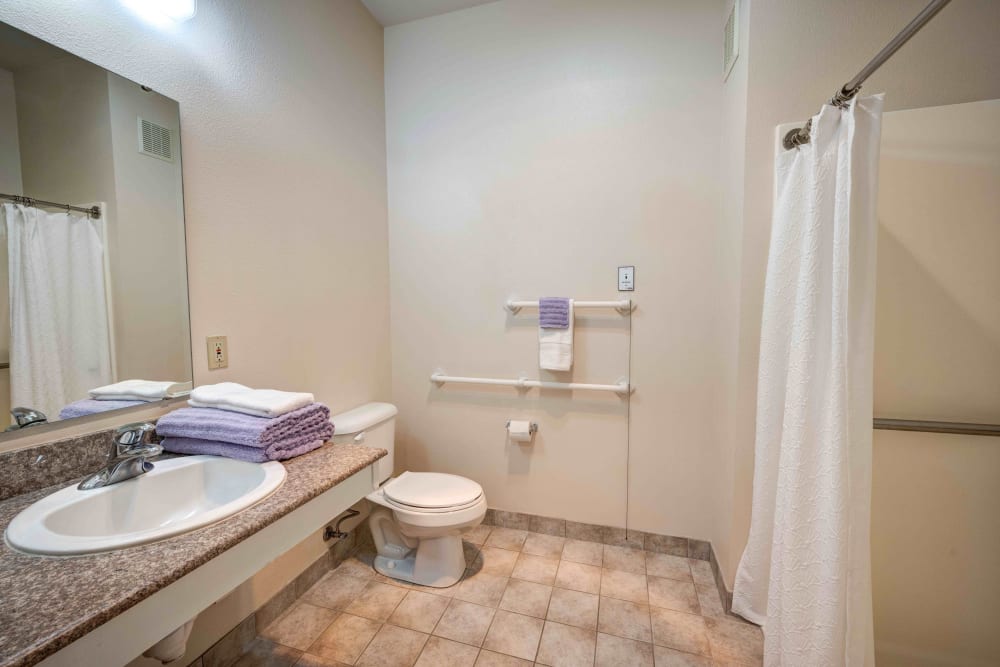 Large bathroom with handrails and a walk-in shower at Callahan Village Retirement  and Assisted Living in Roseburg, Oregon