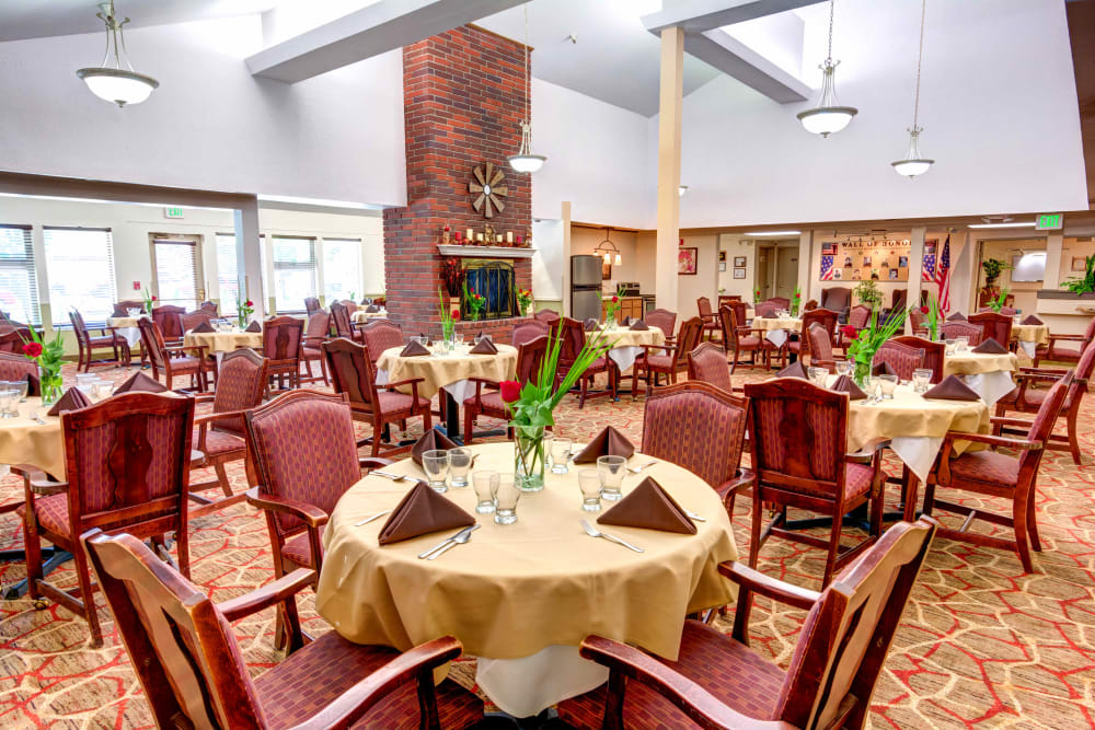 Dining room with cathedral ceilings and a fireplace at Junction City Retirement and Assisted Living in Junction City, Oregon