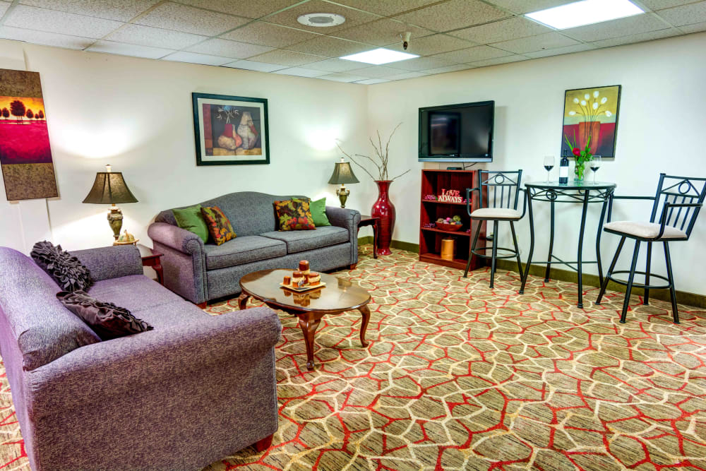 Lounge area with comfortable sofas and a flatscreen TV at Junction City Retirement and Assisted Living in Junction City, Oregon