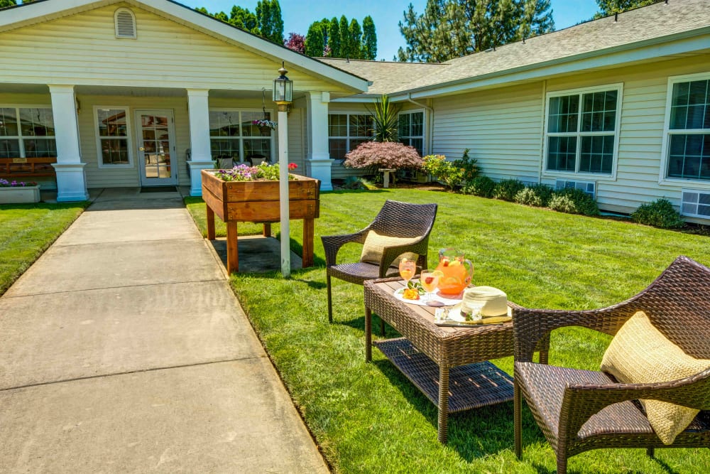 Courtyard with a raised flower bed and lawn seating at Morrow Heights Assisted Living in Rogue River, Oregon