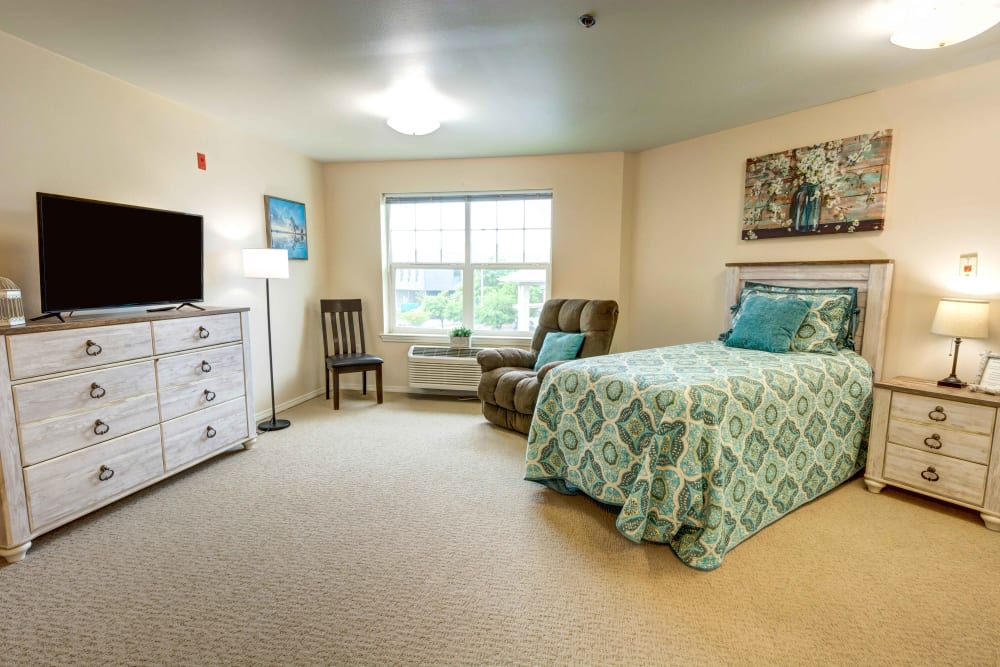 Spacious, carpeted bedroom of a senior apartment at Hawks Ridge Assisted Living in Hood River, Oregon