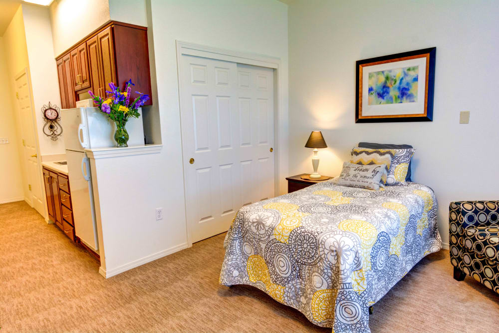 Bedroom and kitchen of a studio apartment at Hawks Ridge Assisted Living in Hood River, Oregon