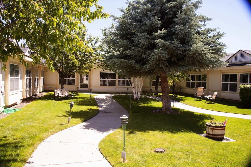 Beautifully landscaped courtyard with a walking path at Settler's Park Senior Living in Baker City, Oregon