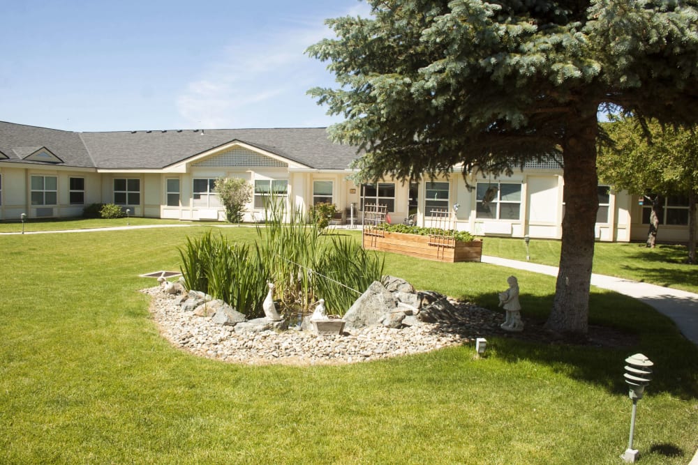 Small pond and raised garden beds on the grounds at Settler's Park Senior Living in Baker City, Oregon