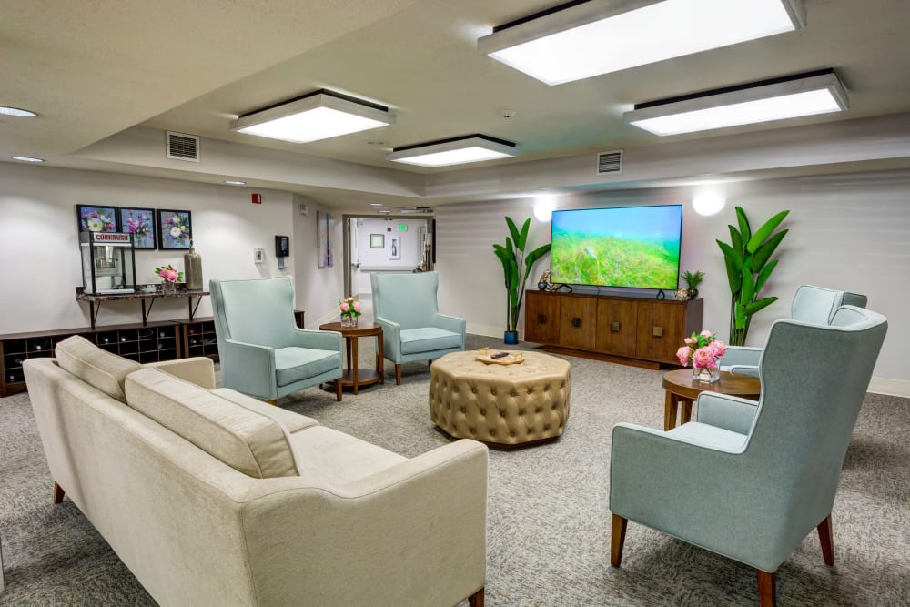 Resident lounge with a large flat screen TV and a popcorn machine at Silver Creek Senior Living in Woodburn, Oregon