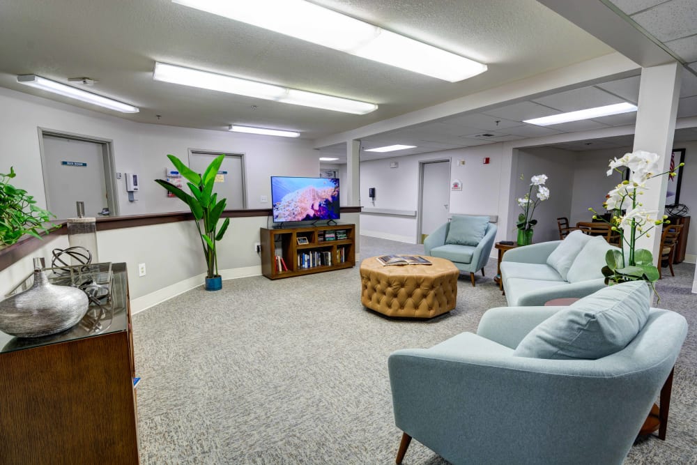 Resident lounge area with a large flatscreen TV at Silver Creek Senior Living in Woodburn, Oregon