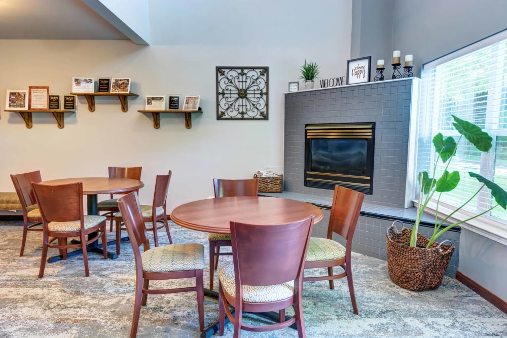 Community common room with a gas fireplace and tables for cards, puzzles, and other activities at The Suites Assisted Living and Memory Care in Grants Pass, Oregon
