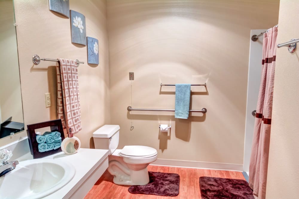 Spacious bathroom with handrails in an apartment at The Suites Assisted Living and Memory Care in Grants Pass, Oregon