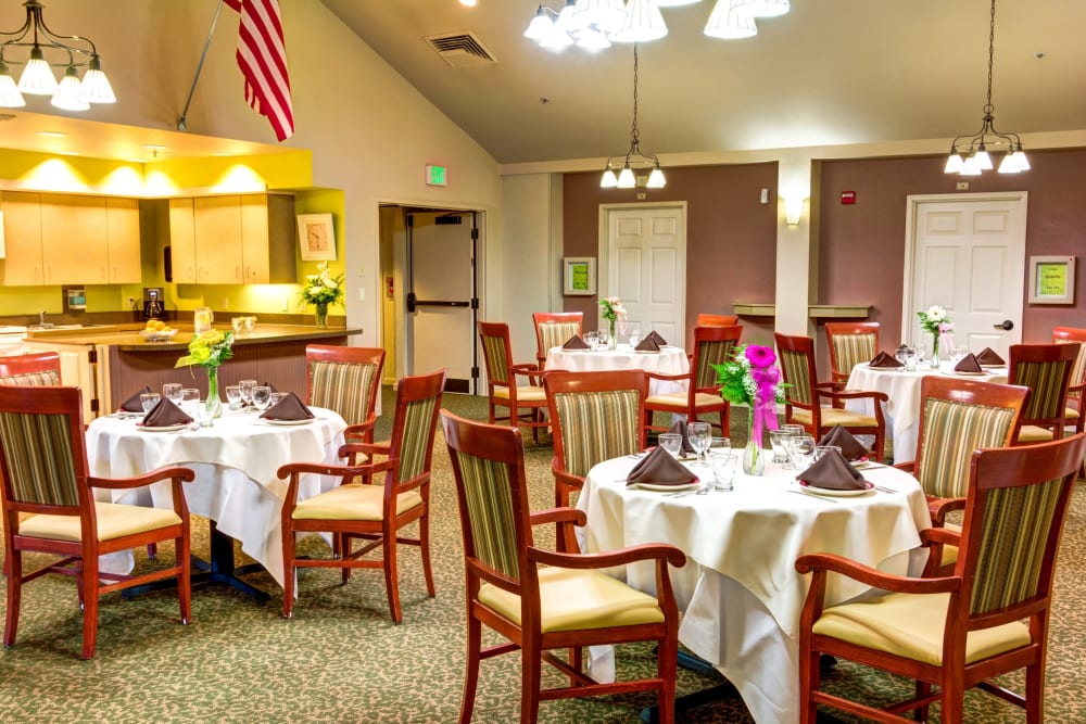 Dining room with cathedral ceilings and community kitchen at Timberwood Court Memory Care in Albany, Oregon