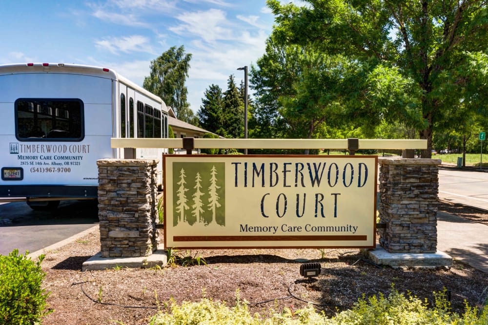 Sign and shuttle bus at the entrance to Timberwood Court Memory Care in Albany, Oregon