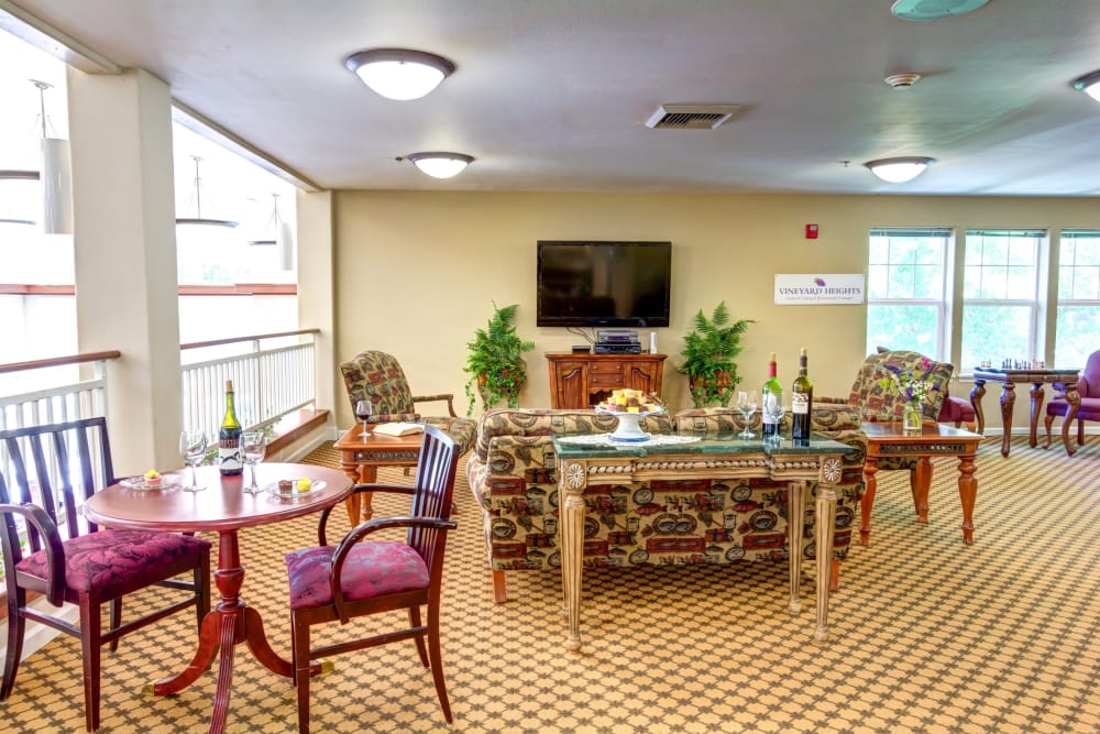 Second floor lounge with a TV and tables for games or gathering at Vineyard Heights Assisted Living in McMinnville, Oregon