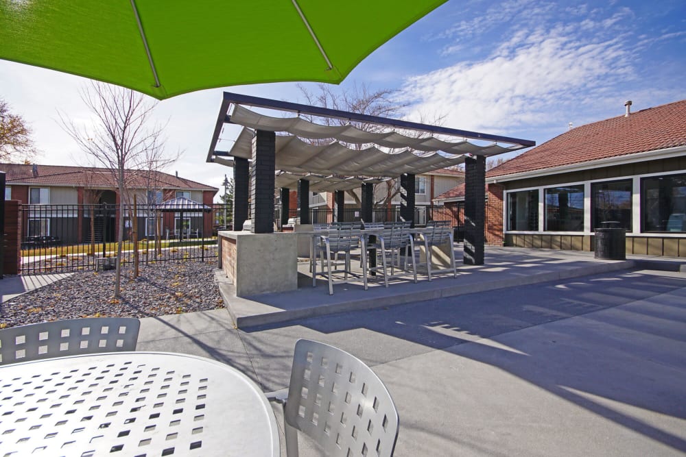 Patio table and chairs with an umbrella at Enclave at Redwood in West Valley City, Utah