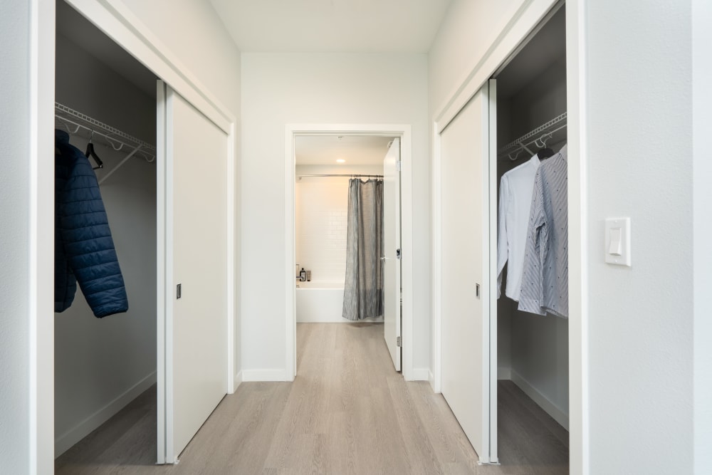 Bedroom with wood-style plank flooring and spacious closets at MV Apartments in Mountain View, California