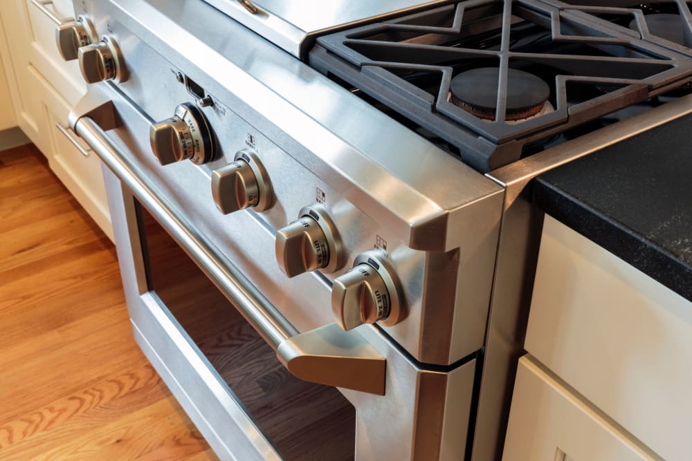 Gas range and hardwood flooring in a model home's kitchen at Mosaic in Los Angeles, California