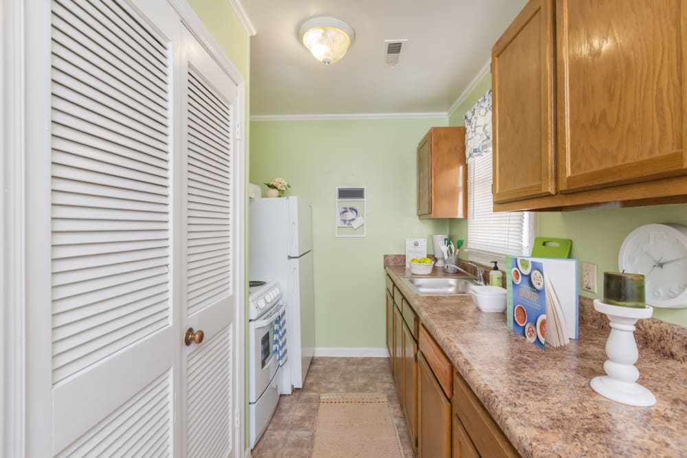 An apartment kitchen and linen closet at Cottage Grove Apartments in Newport News, Virginia