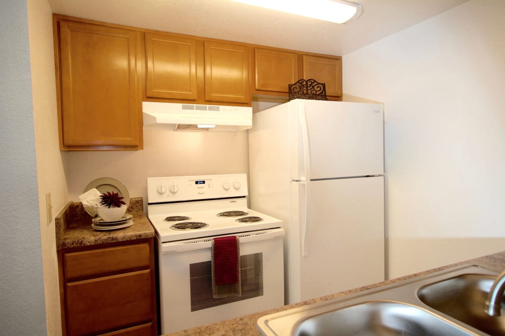 A stove, refrigerator and cabinets in an apartment kitchen at Royal Pointe in Virginia Beach, Virginia 