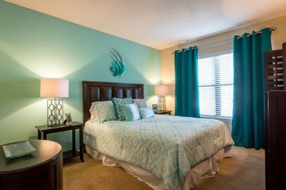 Apartment master bedroom with blue walls and curtains at Acasă Prosper Fairways in Columbia, South Carolina