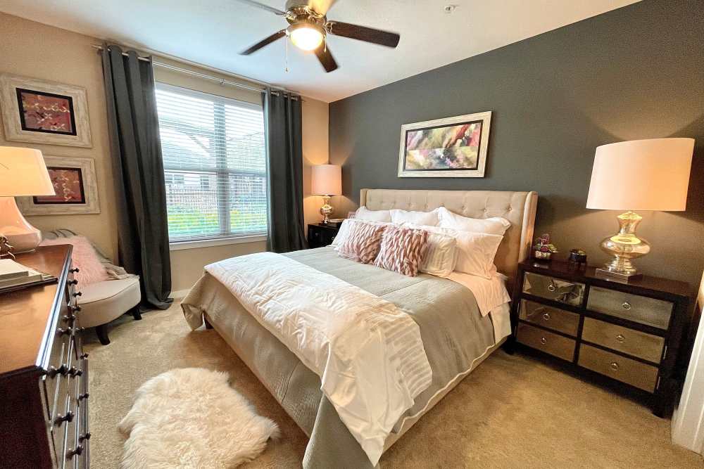 Spacious bedroom with large comfortable bed, desk, and large window at The Abbey at Spring Town Center in Spring, Texas