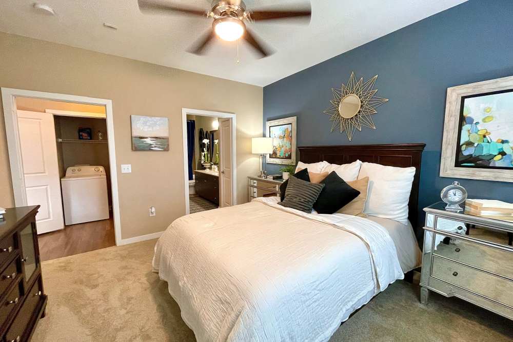 Bedroom with own bathroom, plush carpeting, and ceiling fan at The Abbey at Spring Town Center in Spring, Texas