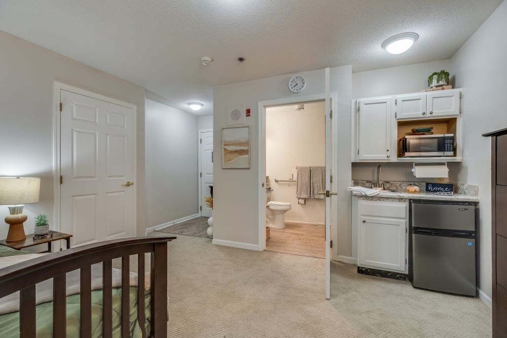 A studio apartment with a bed, small kitchen and bathroom at Village Cove Assisted Living in Hilton Head Island, South Carolina
