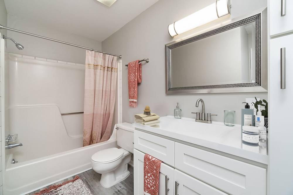 Apartment bathroom with red curtains at Acasă Orchard Park Apartments in Greenville, South Carolina