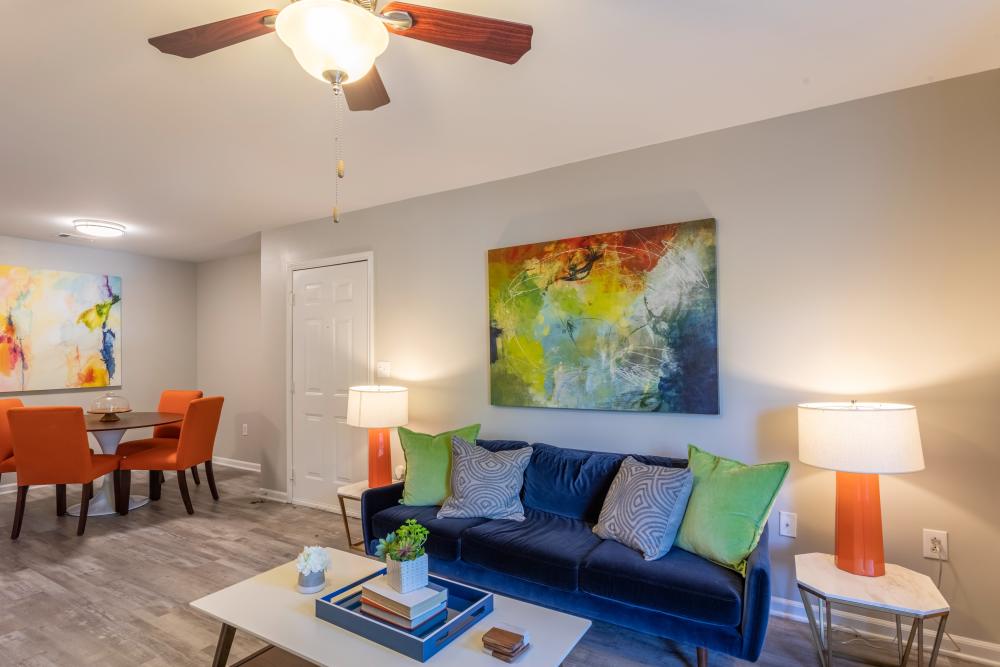 Model apartment bedroom with a ceiling fan and hardwood floors at Acasă Willowbrook Apartments in Simpsonville, South Carolina