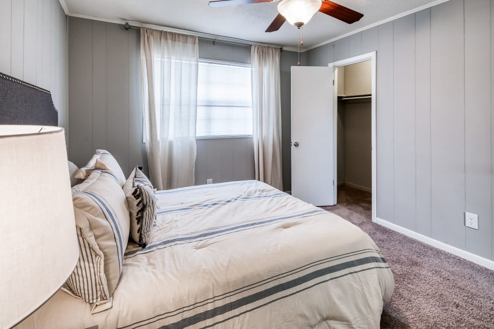 Apartment bedroom with light grey walls and a ceiling fan at Patriot's Place Townhomes in Goose Creek, South Carolina