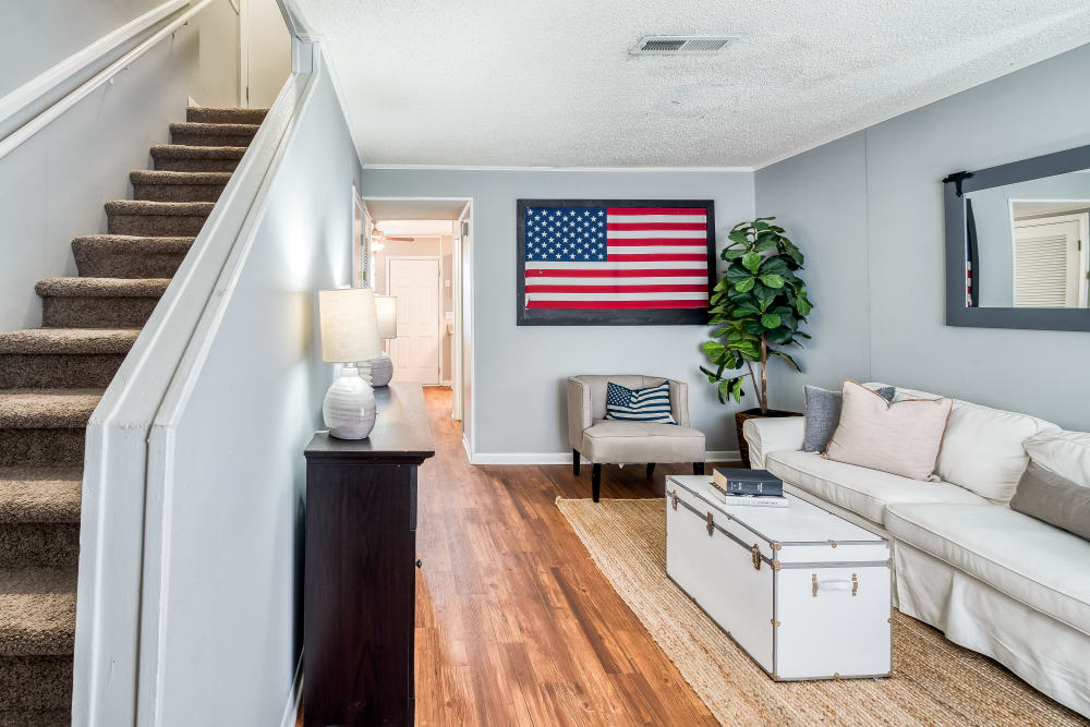 Model apartment living room with an american flag on the wall at Patriot's Place Townhomes in Goose Creek, South Carolina