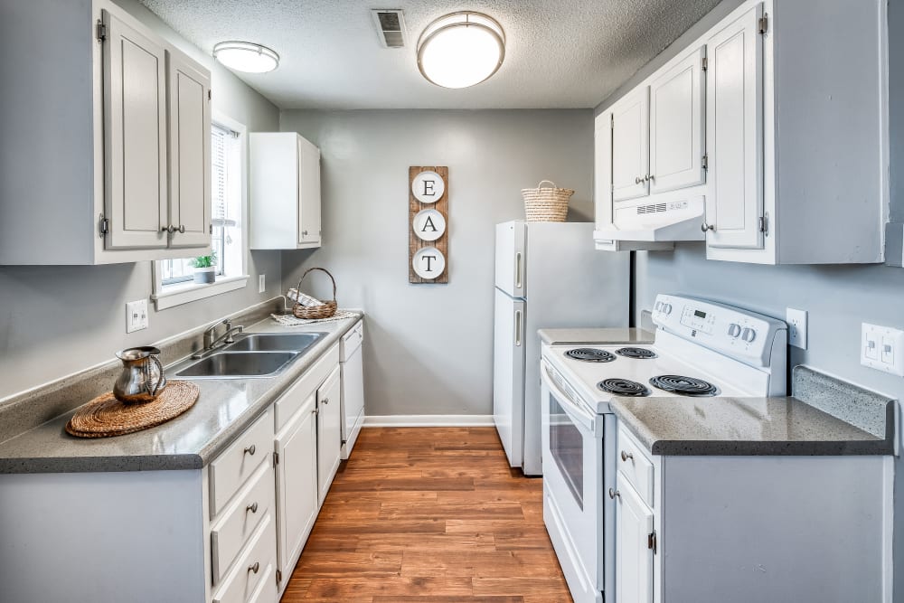 Hallway kitchen with white appliances and cupboards at Patriot's Place Townhomes in Goose Creek, South Carolina