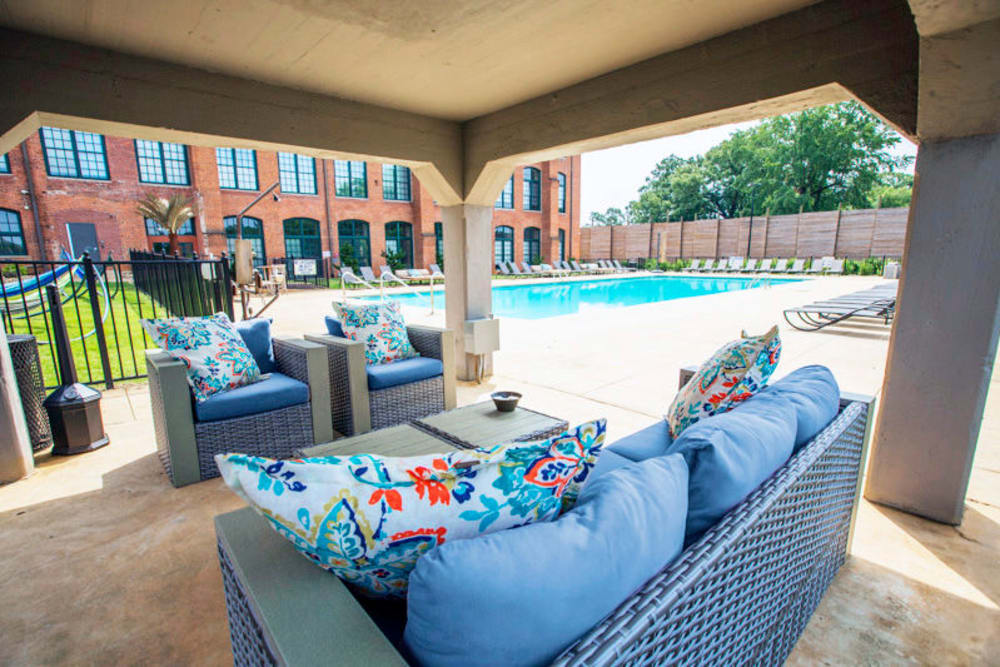 Outdoor lounge seating near our sparkling swimming pool at West Village Lofts at Brandon Mill in Greenville, South Carolina