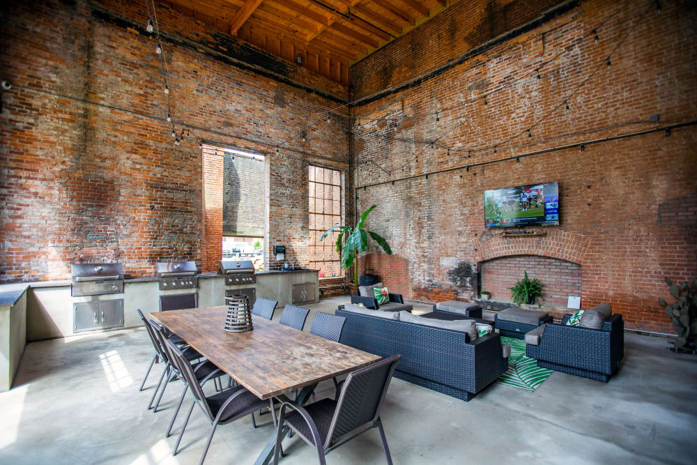 Clubhouse lounge with tv and grill station and plenty of seating at West Village Lofts at Brandon Mill in Greenville, South Carolina