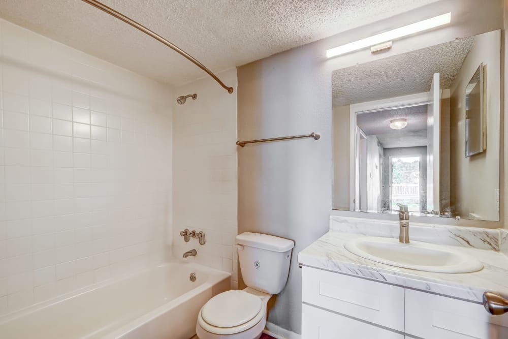An apartment bathroom with a full-sized bathtub at The Park at Northside in Macon, Georgia