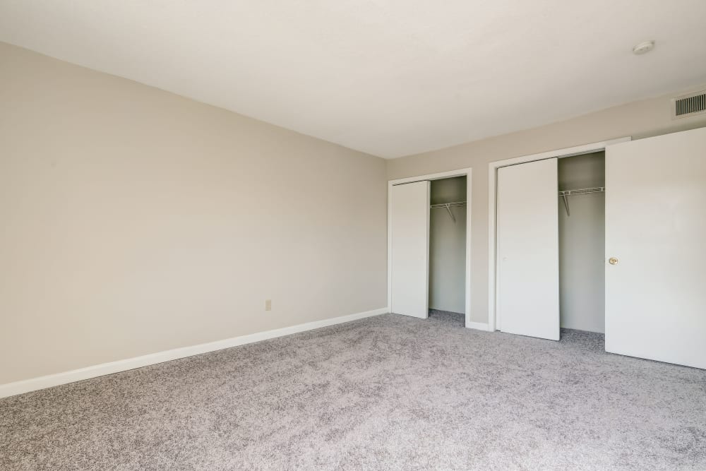 Plush carpet and two doors open to the closets in an apartment bedroom at The Park at Northside in Macon, Georgia