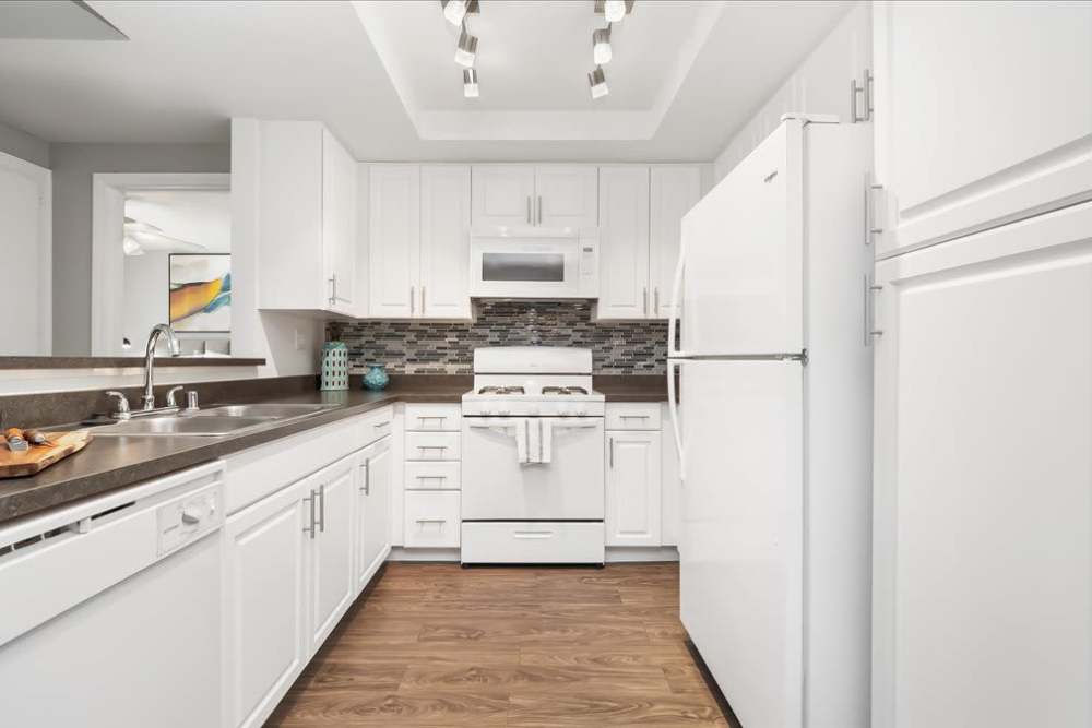 Bright kitchen with white cabinets at  Mirabella Apartments in Bermuda Dunes, California