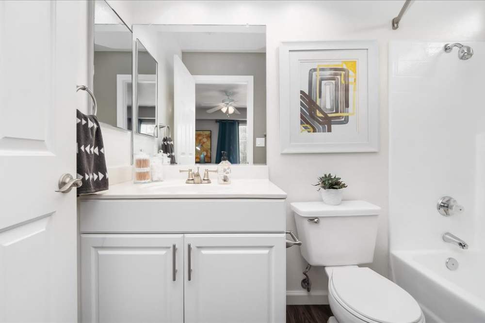 Bathroom with white cabinets in model home at  Mirabella Apartments in Bermuda Dunes, California