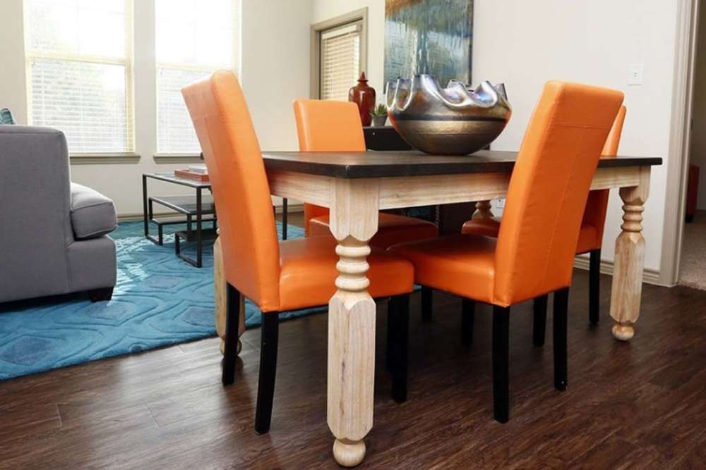Dining area in an apartment with wood-style flooring at Latigo Crossing in Victoria, Texas
