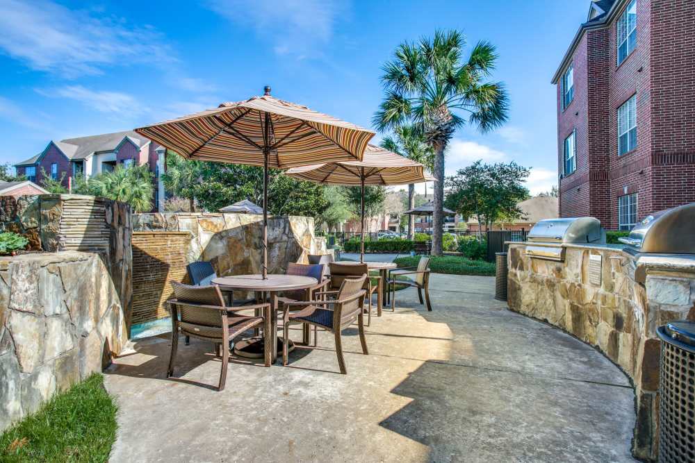 Patio table and chairs with umbrellas at Oak Crest in Houston, Texas