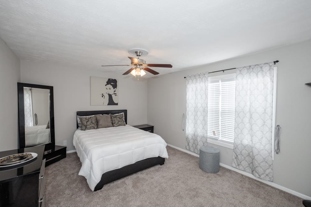 A furnished apartment bedroom with a ceiling fan at LaVista Crossing in Tucker, Georgia