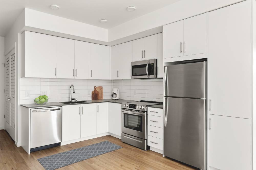 Kitchen with new appliances and wood-style flooring at Helm in Everett, Washington