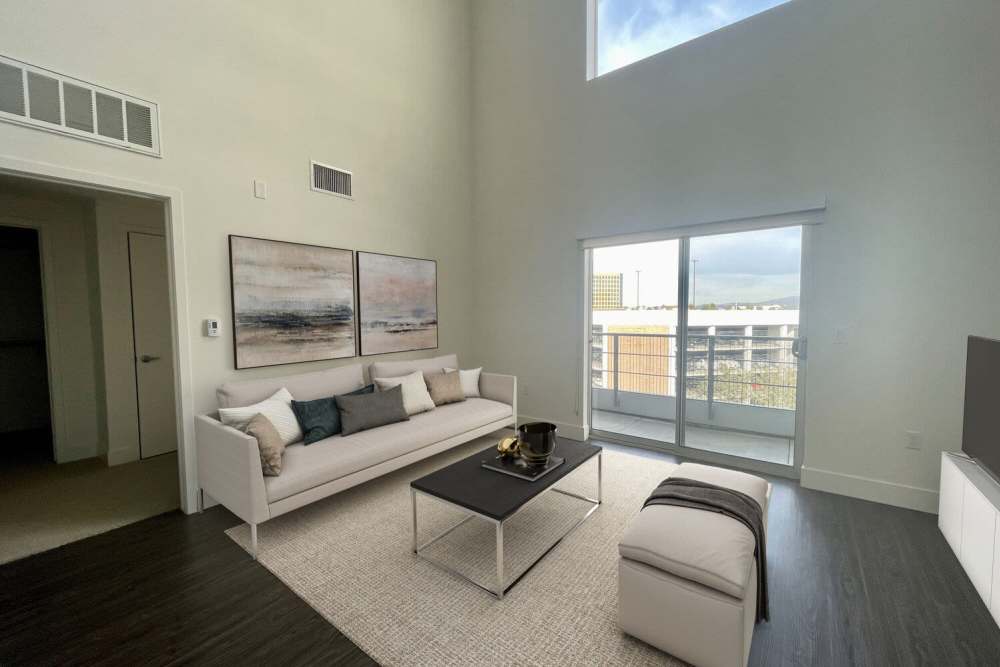 Spacious living room with a sliding door leading to the private balcony at The Marke Apartment Homes in Santa Ana,
