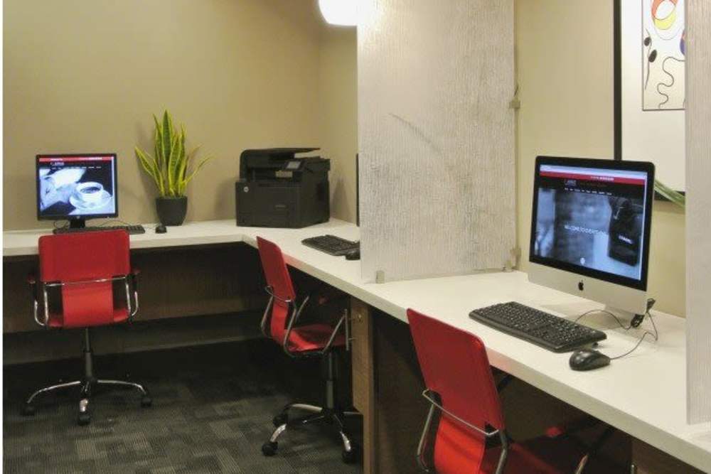 Business center with multiple desktops at The Marke Apartment Homes in Santa Ana, California