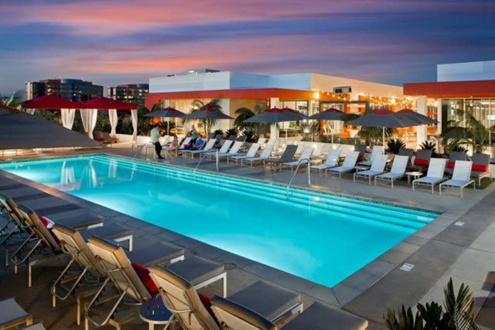Swimming pool with lounge chairs at The Marke Apartment Homes in Santa Ana, California